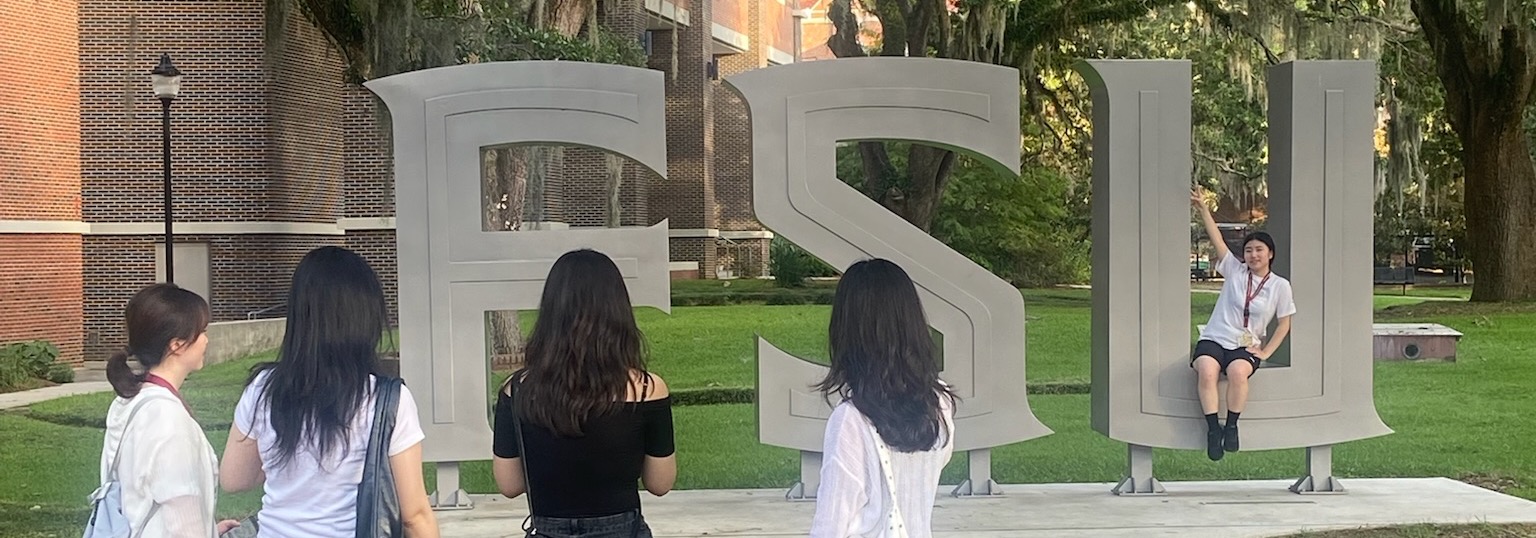 Students taking photo at FSU sign