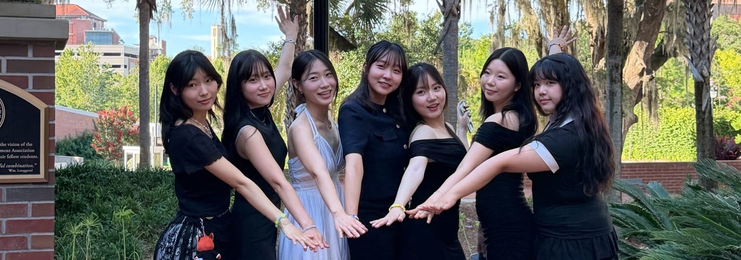 Students Placing Hands Towards Center of Picture